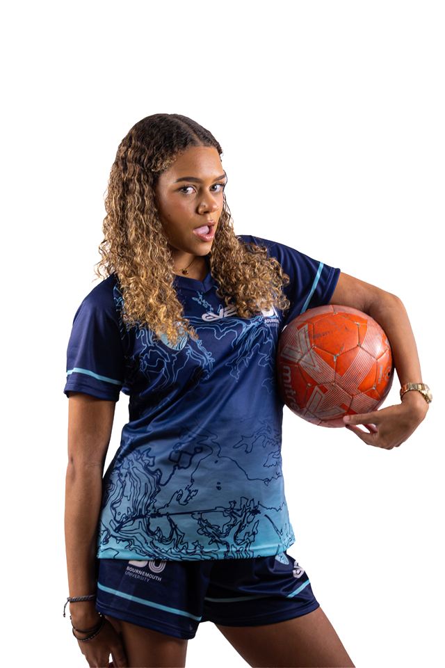 A player holding a ball under one arm and smiling