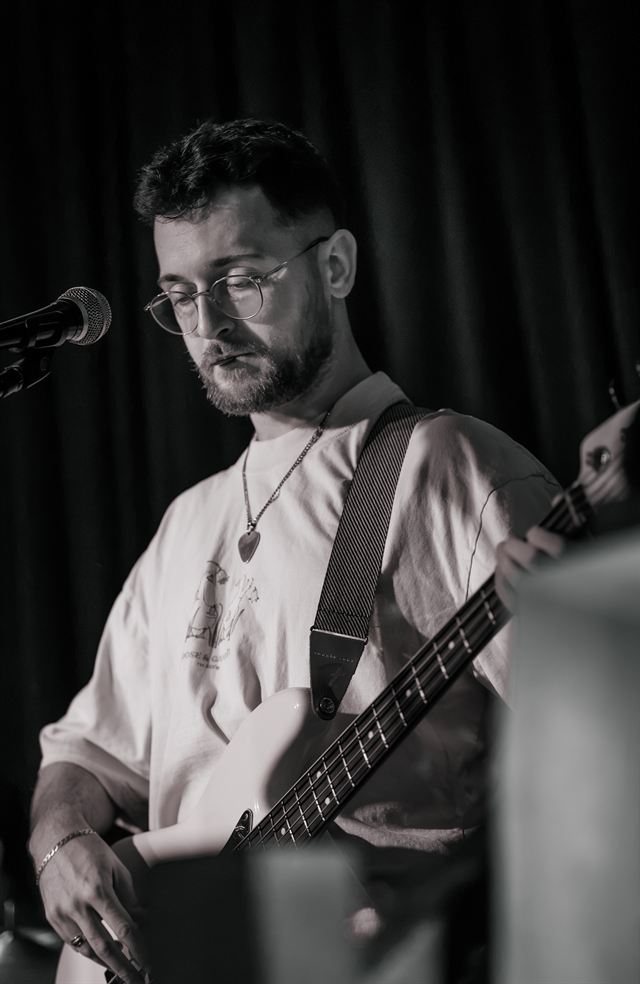 A black and white shot of a guitarist singing