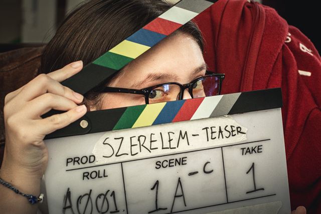 An actor peeking over a clapperboard